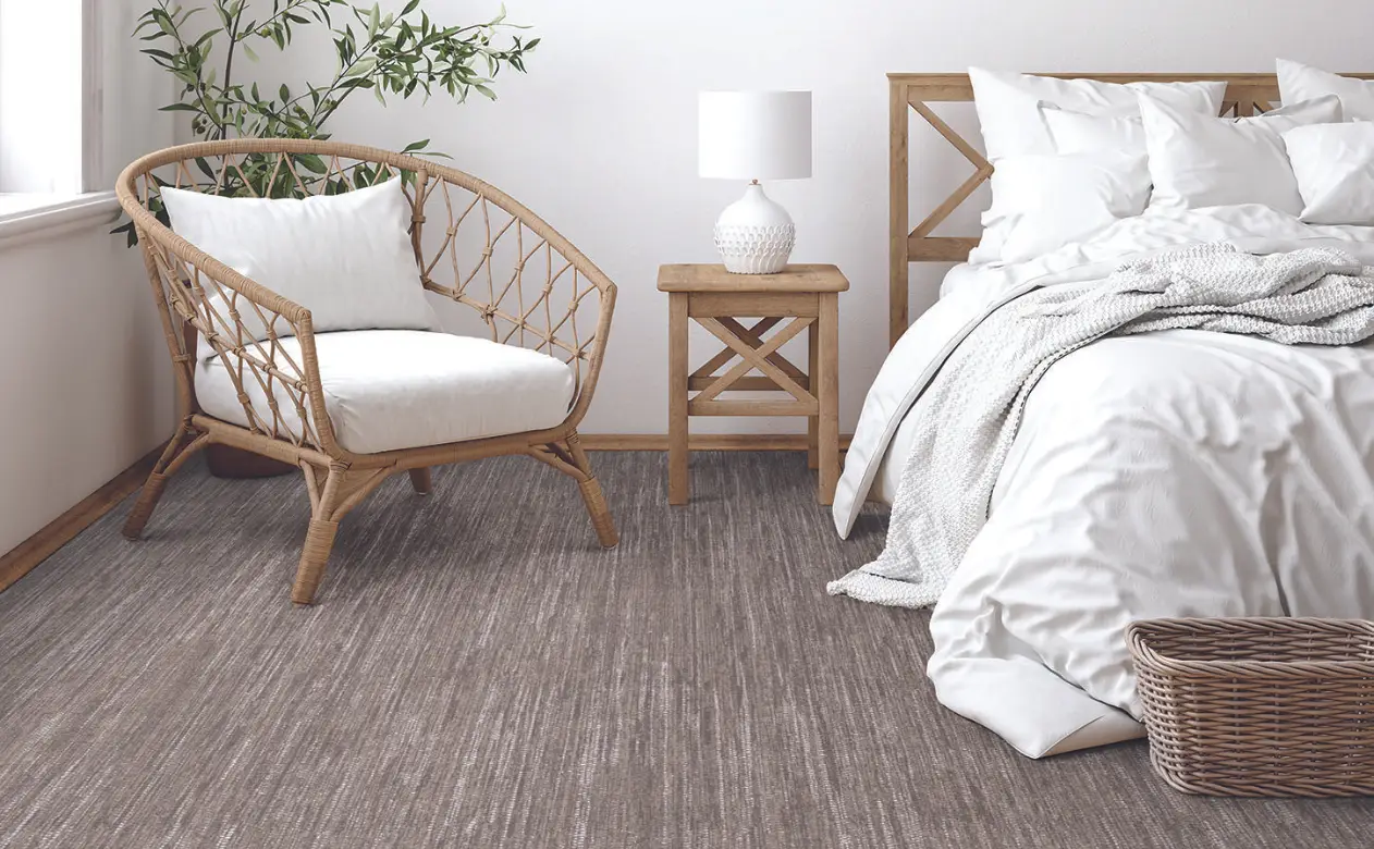 Living room with bright white and natural furniture and pattern carpet.